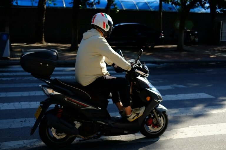 Motorista circulando en scooter por la ciudad