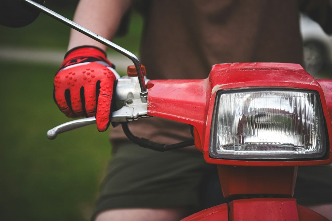 Motorista con guantes de moto en scooter
