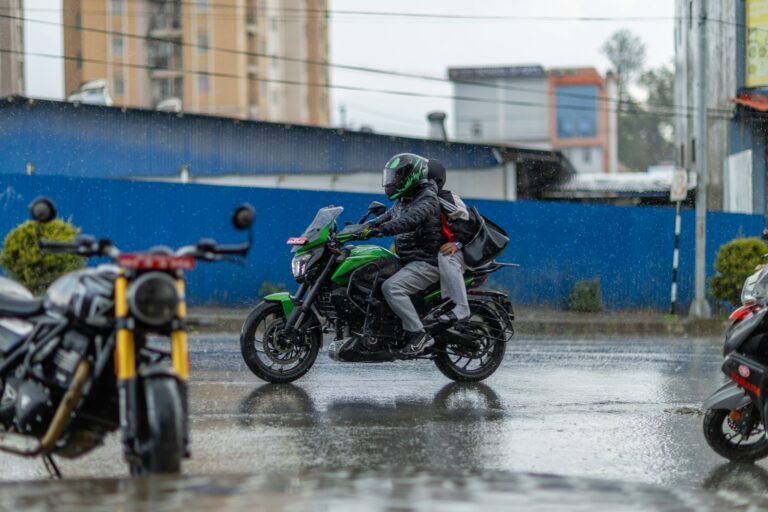 Motorista circulando en moto bajo la lluvia con guantes